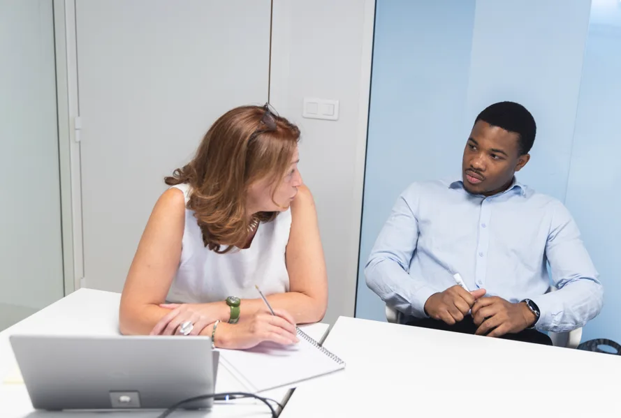 One-to-one coaching session between an employee and her trainer around a CPF training project